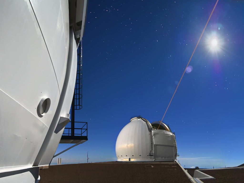 In this view from the Keck Observatory rooftop, the Keck II Laser Guide Star probes the sky as a waxing moon ascends above the summit of Mauna Kea.